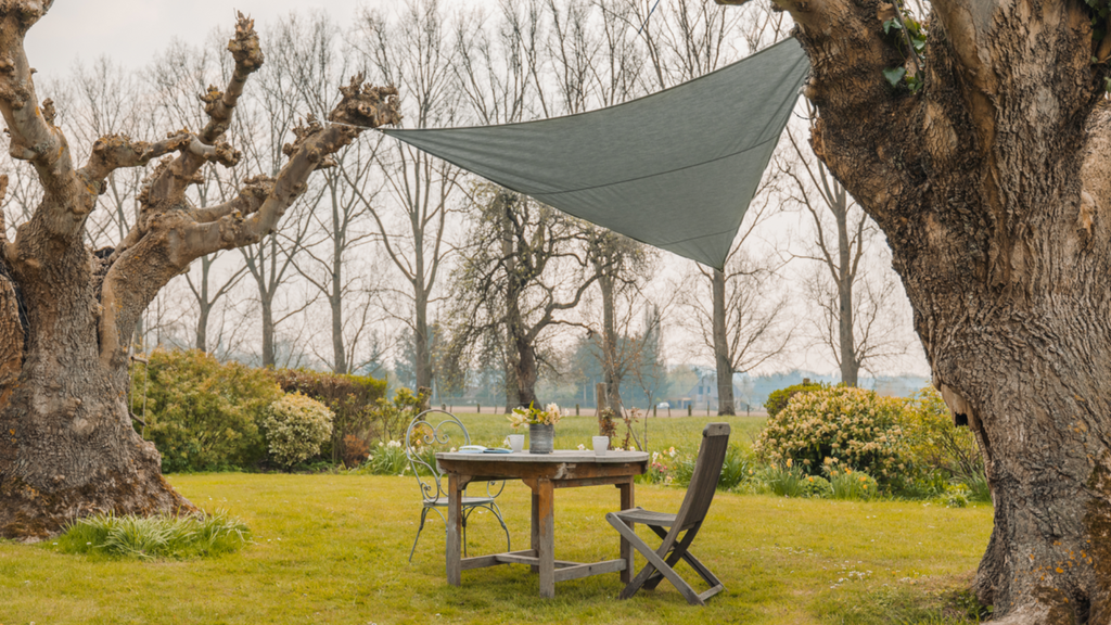 Une voile d'ombrage installée aux arbres dans un jardin