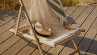 Un chapeau de paille sur une chaise de jardin 