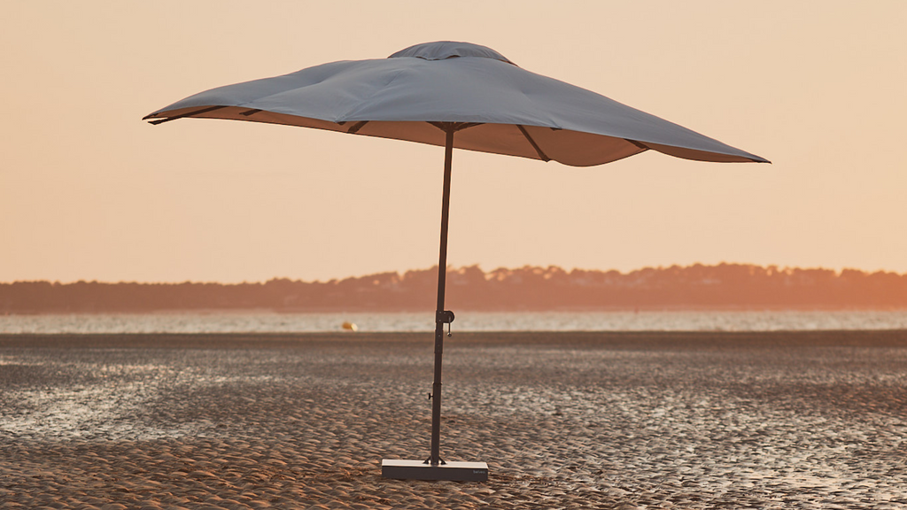 Un parasol droit sur du sable