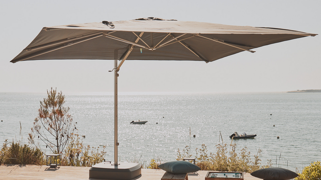 Un parasol déporté sur une terrasse en bord de mer