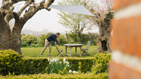 Un homme sous sa voile d'ombrage dans son jardin 