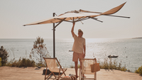 Un homme remplaçant la toile de son parasol 