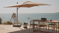Un grand parasol déporté sur une terrasse  